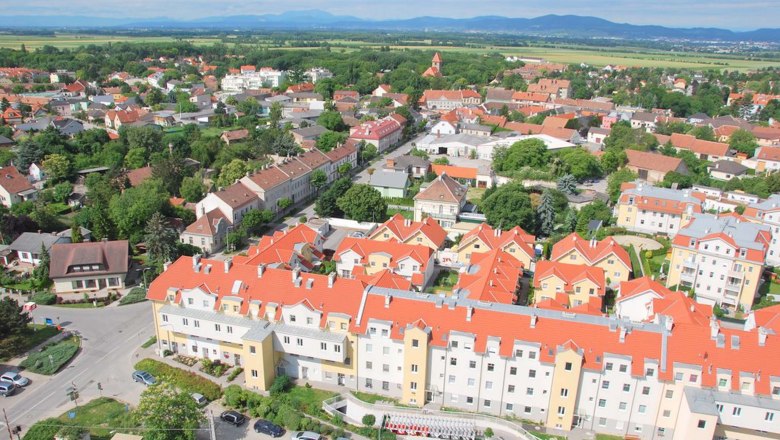 Luftaufnahme von Himberg mit roten Dächern und grüner Landschaft.
