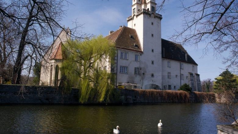 Schloss Ebreichsdorf mit Teich und Schwänen im Vordergrund.