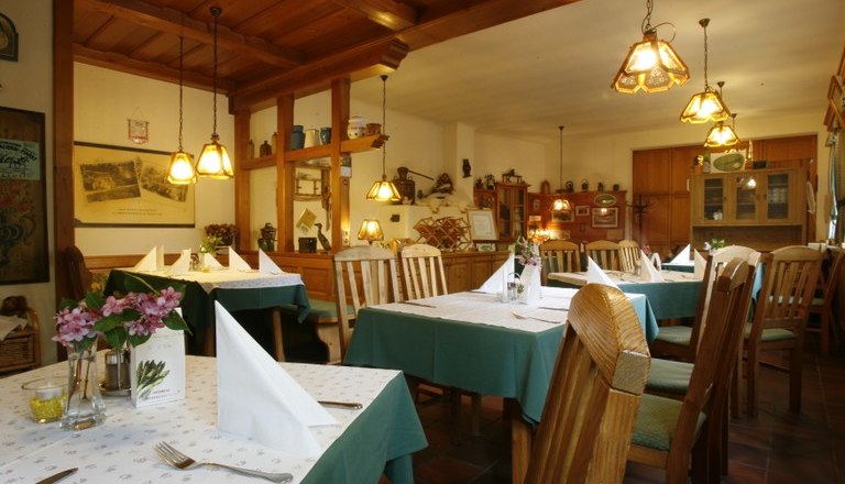 Bonka - Das Wirtshaus im Wienerwald, © Bonka Innenansicht eines gemütlichen Wirtshauses mit Holzmöbeln und gedeckten Tischen.