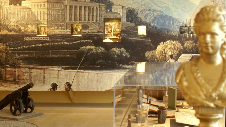 Innenansicht eines Museums mit B&uuml;ste, Kanone und Wandgem&auml;lde.