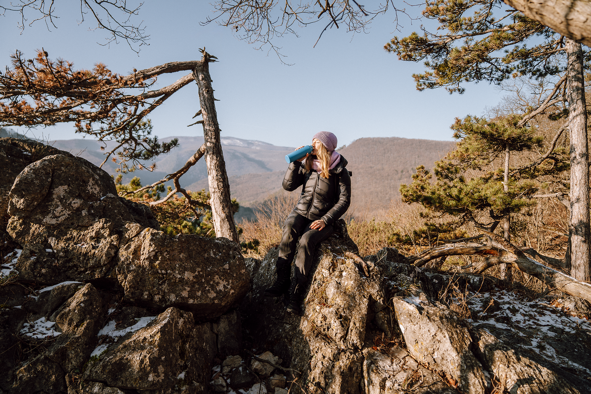 In der winterlichen Stille des Helenentals genießt eine Wanderin die frische Bergluft und den atemberaubenden Ausblick auf die schneebedeckten Gipfel. Umgeben von majestätischen Fichten und rauen Felsen, lädt die winterliche Landschaft zu einer erholsamen Auszeit in der Natur ein.