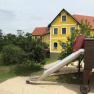 Yellow building with red roof and slide in the foreground.
