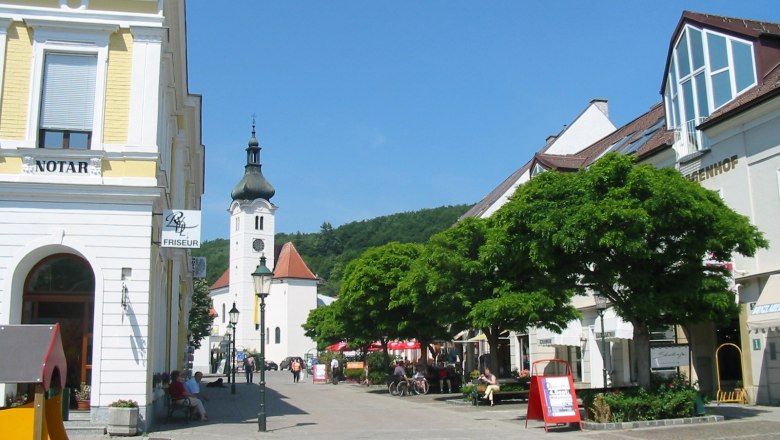 Hauptplatz in Purkersdorf mit Kirche und Gesch&auml;ften.