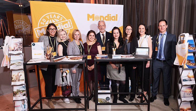 Group of people in front of a Mondial banner at an event.