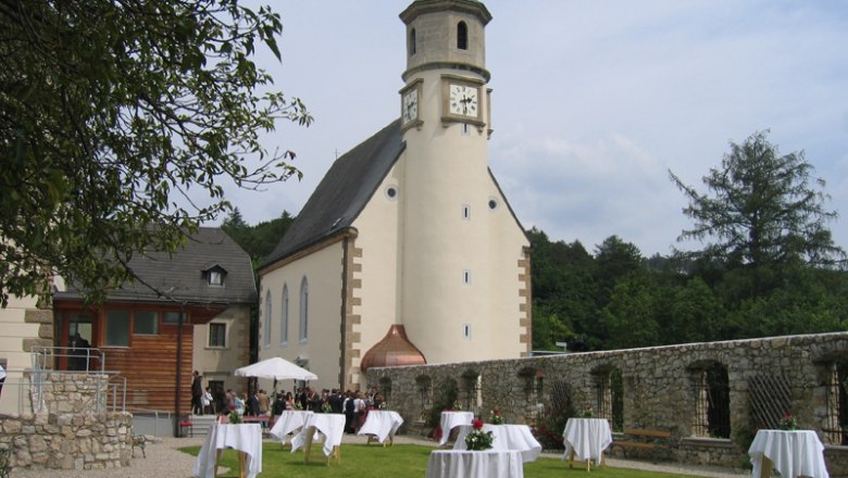 Kirche mit Turm und Garten mit Stehtischen, Hochzeitsszene.