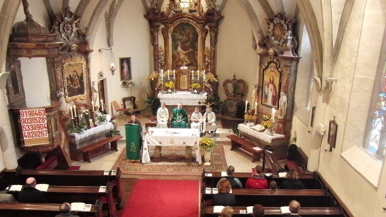 Interior view of a church during a mass with clergy and faithful.