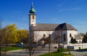 Kirche in Trumau mit blauem Himmel im Hintergrund.