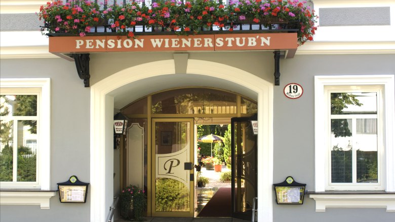 Eingang der Pension Wienerstub'n mit Blumen und Hausnummer 19.