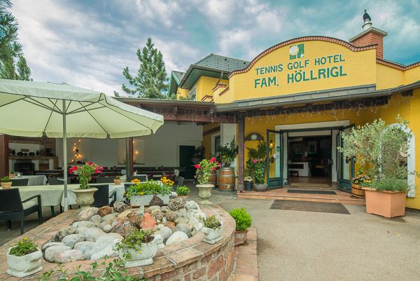 Eingang des Tennis Golf Hotels Höllrigl mit Terrasse und Pflanzen.