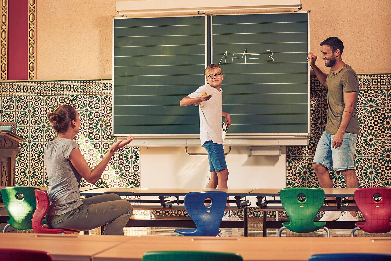 In einem einladenden Klassenzimmer voller Farben und Kreativität wird das Lernen zum Abenteuer. Eine Familie genießt die Zeit miteinander, während sie spielerisch Wissen vermittelt. Die harmonische Atmosphäre lädt dazu ein, die Schönheit der Natur und die Freude am gemeinsamen Entdecken zu erleben.