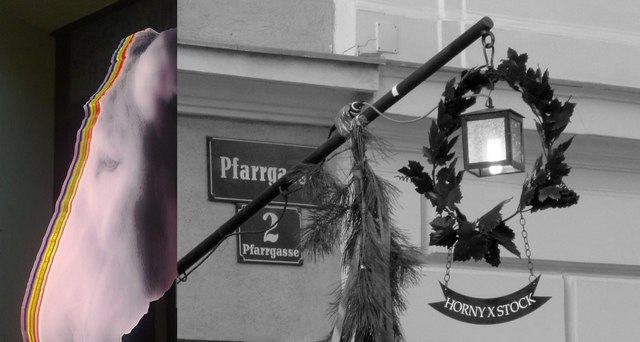 Ein Eselskopf mit bunten Streifen neben einem Straßenschild und einer Laterne mit Kranz.