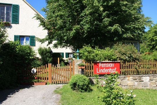 House, © Pension Lindenhof A house with a garden and a "Pension Lindenhof" sign on the wooden fence.