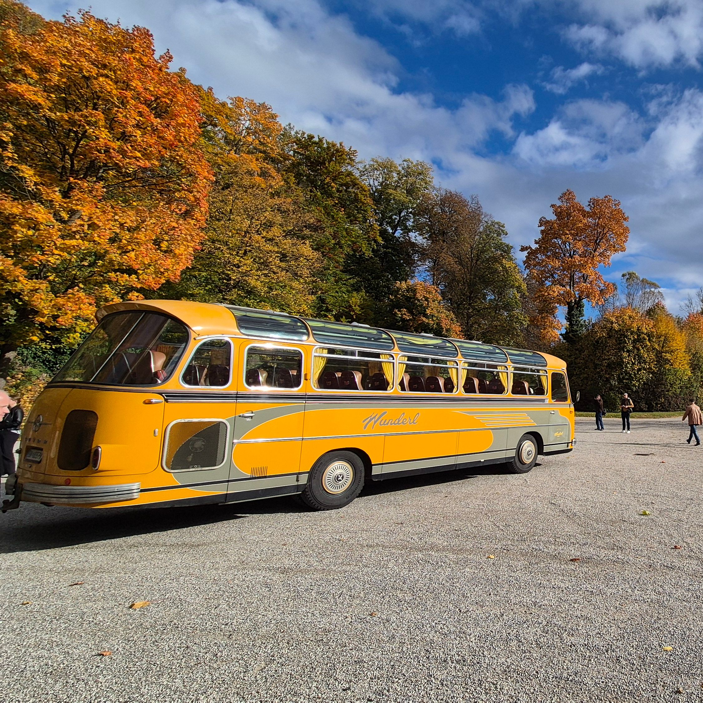Oldtimer Bus vor herbstlichem Wald